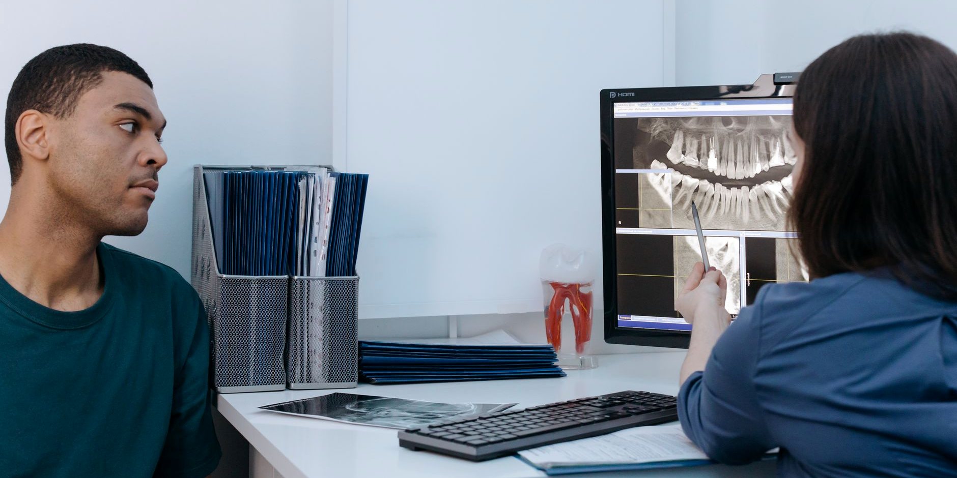 A dentist showing a patient their x-ray on screen