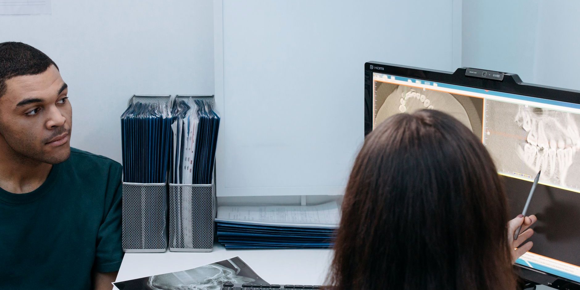 A dentist talking a patient through their x-ray