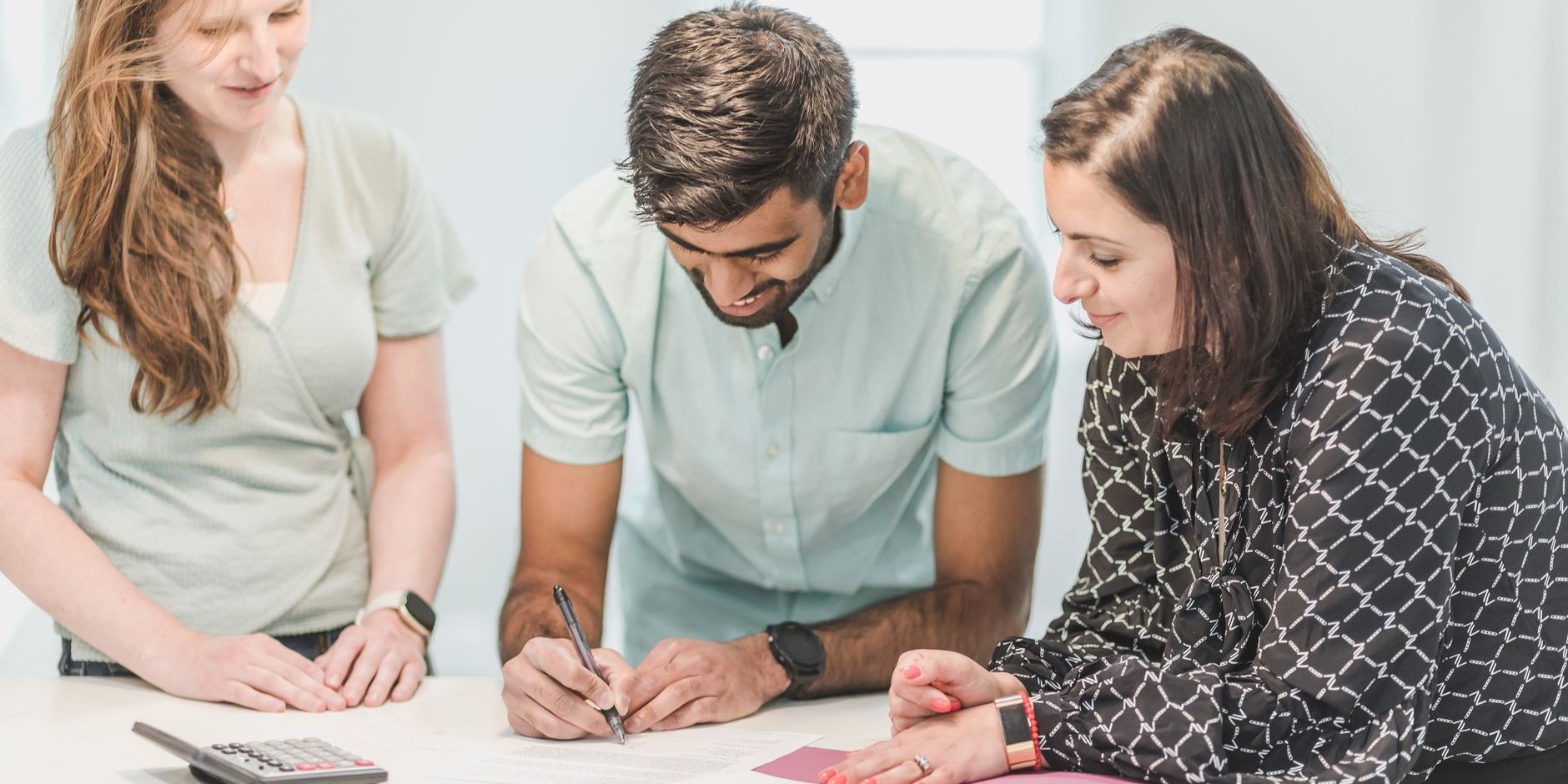 Three people going through paperwork at a table