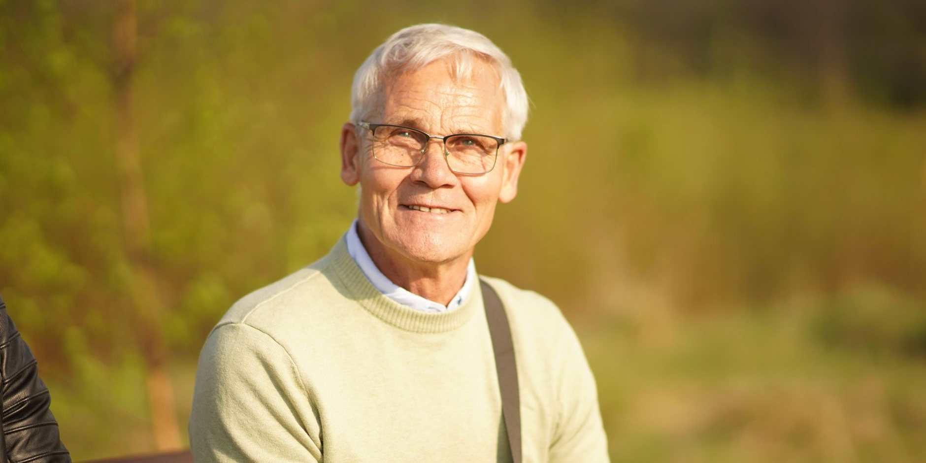 An older man smiling outdoors